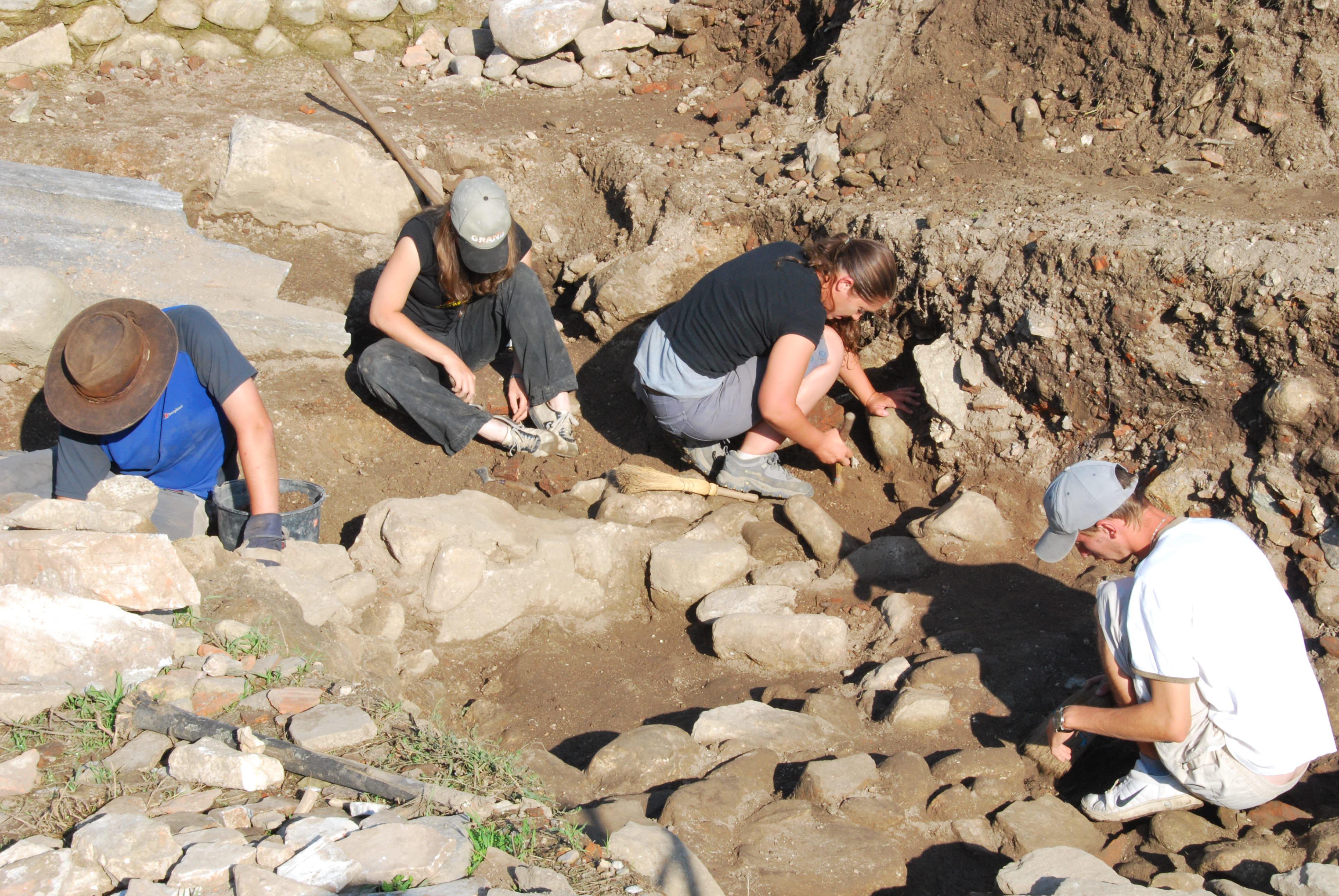 Projects Abroad volunteers on the Archaeology Project in Romania for teenagers help excavate a dig site. Young volunteers assist with site excavation while Archaeology volunteering in Romania for teens.